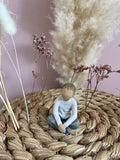 Statuette Willow Tree Imaginative Child par Susan Lordi : Petit garçon assis dans une attitude réveuse en résine peinte façon bois, collection Les roses de mon jardin, idéale pour compléter une famille ou une fratrie.