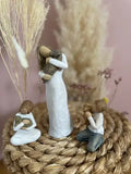 Statuette Willow Tree Kindness Garçon : Jeune garçon à genoux tenant son chiot, figurine en résine peinte façon bois, tendresse et amour entre enfant et animal de compagnie.