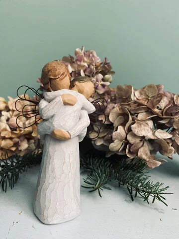 Statuette Willow Tree Embrace par Susan Lordi, résine peinte façon bois, ailes en métal, représentant un ange gardien étreignant avec amour un petit enfant, symbole de protection et de tendresse