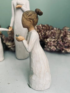 Statuette Willow Tree Nurture par Susan Lordi, résine peinte façon bois, représentant une petite fille à la queue de cheval protégeant délicatement un oiseau dans ses mains, symbole du soin et de la protection.