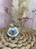 Statuette Willow Tree Spirited Child par Susan Lordi : Petite fille assise dans une attitude pensive en résine peinte façon bois, collection Les roses de mon jardin, idéale pour compléter une famille ou une fratrie